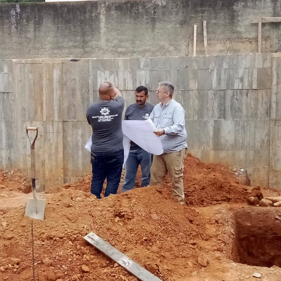 Revisión de planos por la cuadrilla junto a la excavación de cimientos