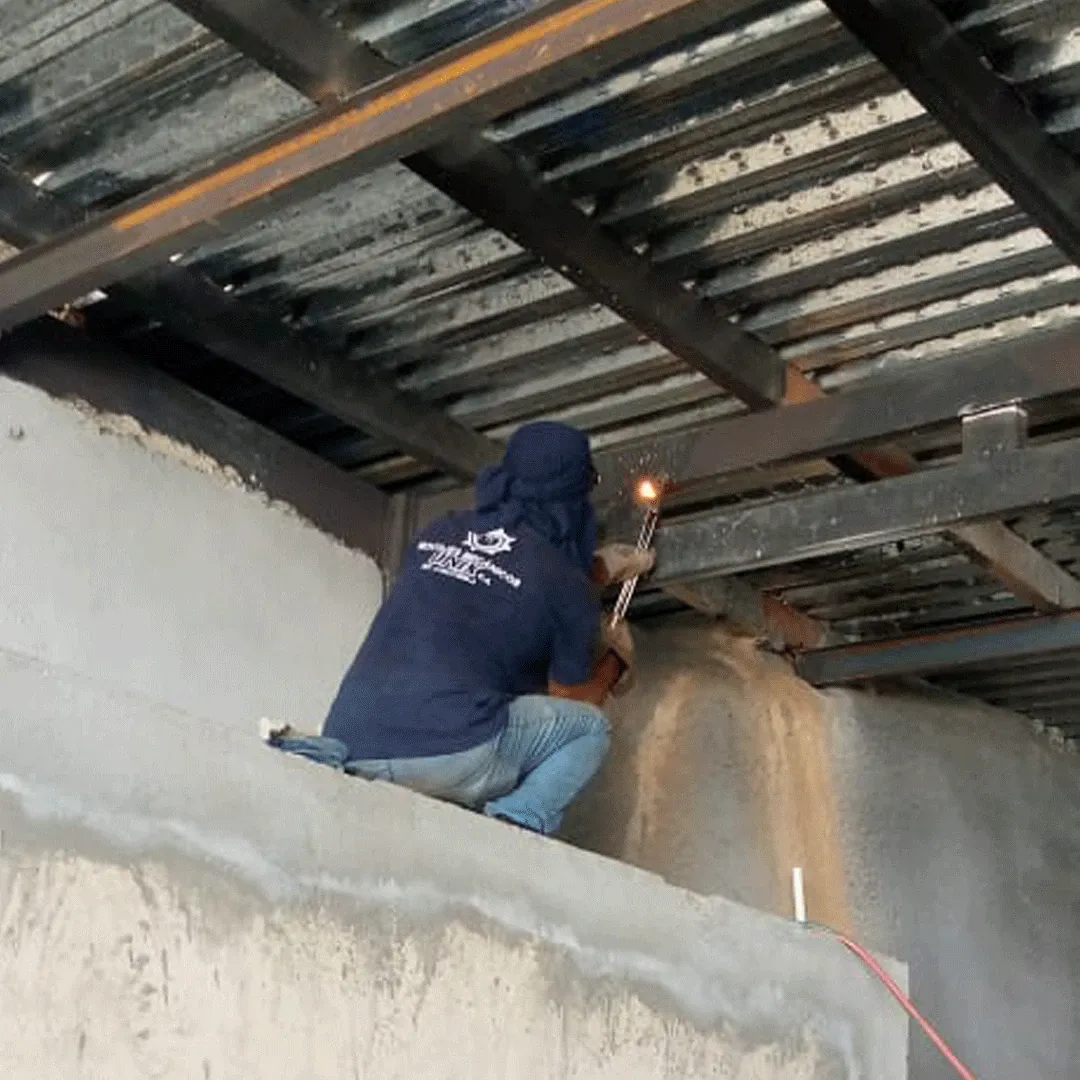 Soldadura de una estructura elevada apoyada en un muro de concreto